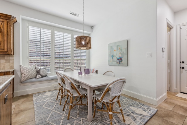 dining room featuring light tile patterned flooring, visible vents, and baseboards