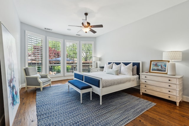 bedroom featuring dark wood finished floors, visible vents, baseboards, and ceiling fan