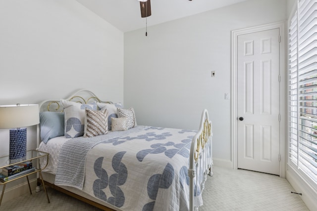 bedroom with ceiling fan, carpet floors, multiple windows, and baseboards