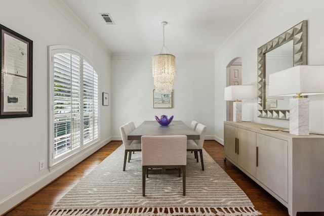 dining room with dark wood-style flooring, visible vents, a chandelier, and crown molding
