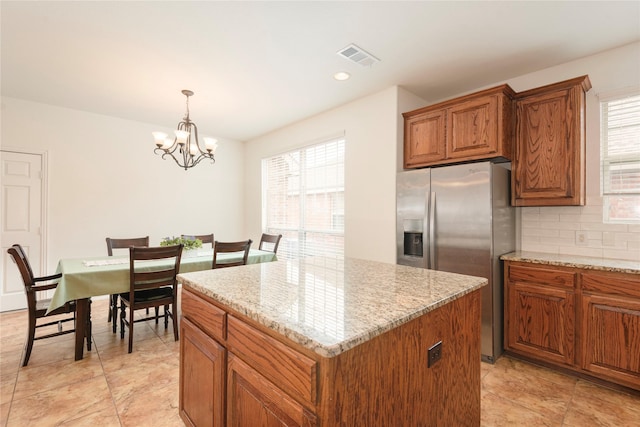 7014 Handen Dr, Rowlett, TX 75089 - kitchen featuring stainless steel fridge, healthy amount of natural light, brown cabinets, a center island, and recessed lighting