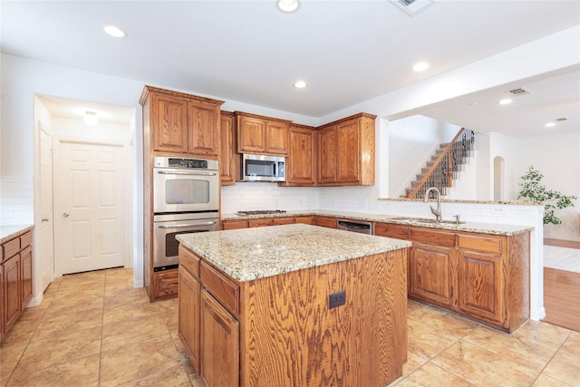 7014 Handen Dr, Rowlett, TX 75089 - kitchen with stainless steel appliances, brown cabinets, a kitchen island, backsplash, and light stone countertops