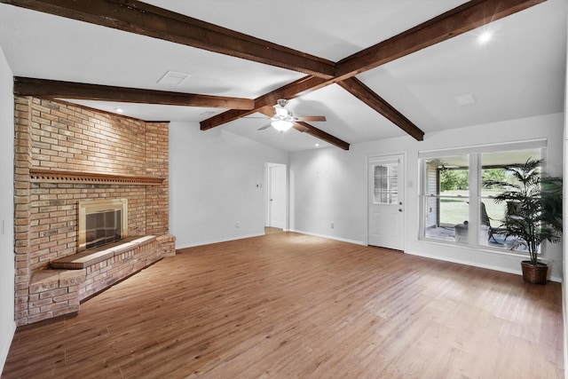 unfurnished living room featuring baseboards, a fireplace, a ceiling fan, vaulted ceiling with beams, and wood finished floors