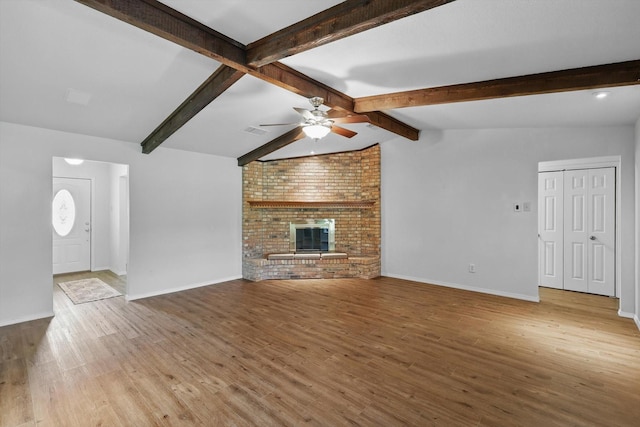 unfurnished living room featuring vaulted ceiling with beams, baseboards, wood finished floors, and ceiling fan