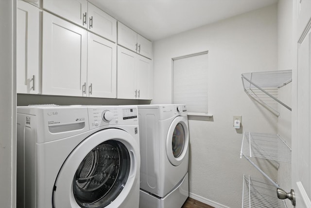 laundry room featuring cabinet space, washing machine and clothes dryer, baseboards, and dark wood-style floors