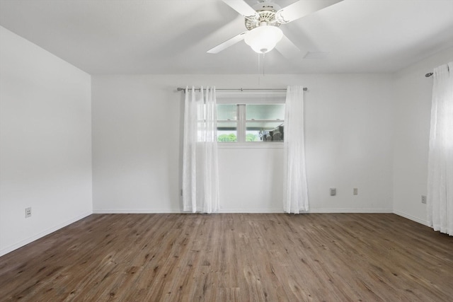 spare room with baseboards, a ceiling fan, and wood finished floors