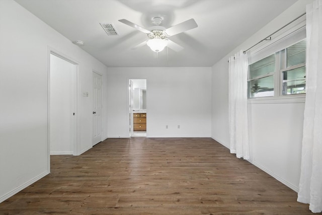 spare room with wood finished floors, baseboards, a ceiling fan, and visible vents