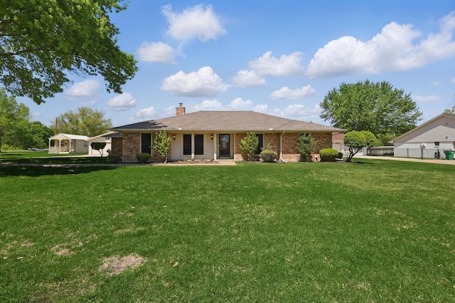 back of house featuring brick siding, a lawn, and a chimney