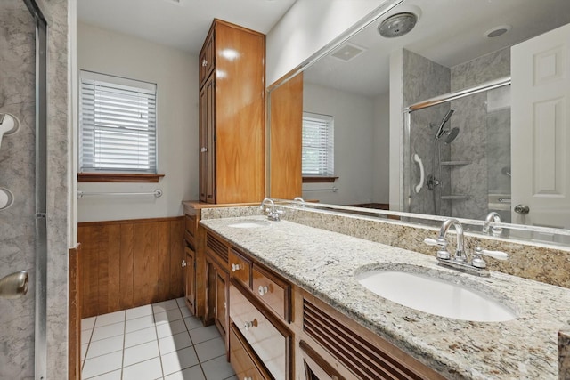bathroom with a sink, a shower with door, and plenty of natural light