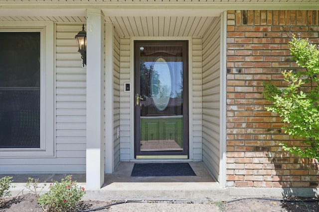 view of exterior entry featuring brick siding
