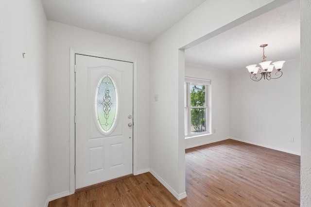 foyer featuring a chandelier, baseboards, and wood finished floors