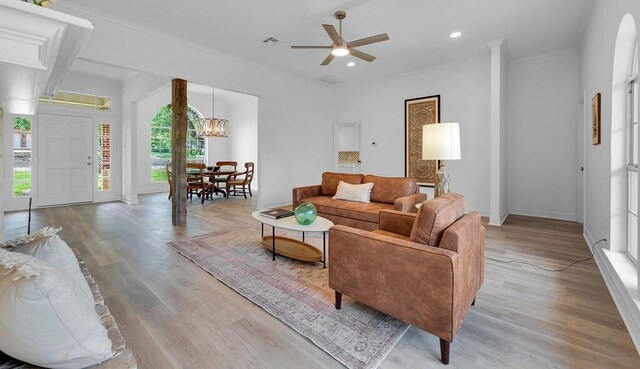 living room featuring ceiling fan with notable chandelier, light wood-style flooring, baseboards, and recessed lighting