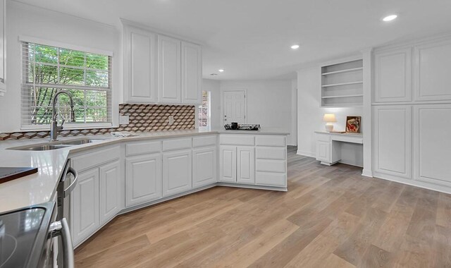 kitchen featuring white cabinets, a sink, recessed lighting, light wood-style floors, and decorative backsplash