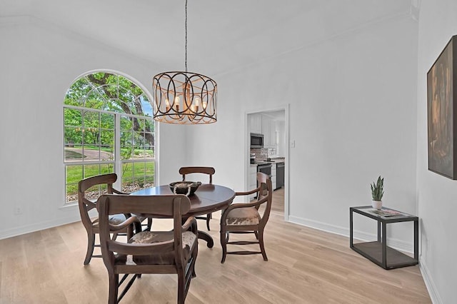 dining area featuring plenty of natural light, light wood-style flooring, and an inviting chandelier