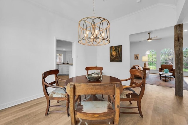 dining room featuring baseboards, crown molding, ceiling fan with notable chandelier, and light wood-type flooring
