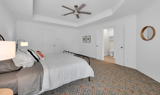 carpeted bedroom featuring ceiling fan, crown molding, ensuite bathroom, and a raised ceiling