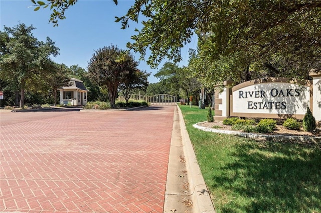 exterior space with a gated entry, curbs, and a gate