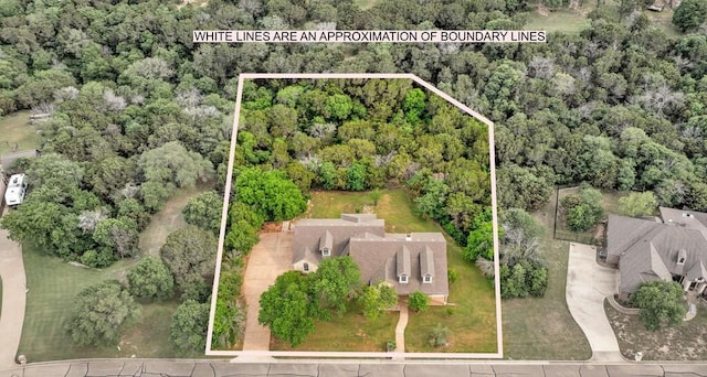 bird's eye view with a wooded view