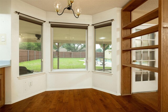 doorway with baseboards, a chandelier, and wood finished floors