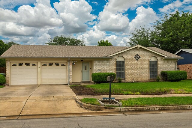 ranch-style house featuring a front lawn, roof with shingles, brick siding, an attached garage, and driveway