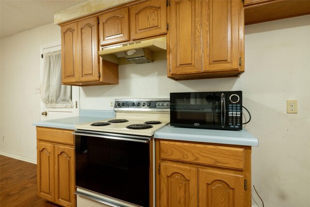 kitchen with dark wood-style flooring, black microwave, light countertops, electric stove, and under cabinet range hood