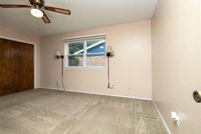 unfurnished bedroom with baseboards, carpet flooring, a textured ceiling, and a closet