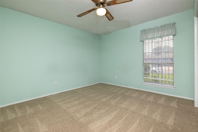 carpeted empty room featuring baseboards, ceiling fan, and a textured ceiling