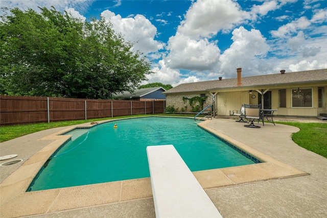 view of pool featuring a patio, a fenced backyard, a diving board, and a fenced in pool