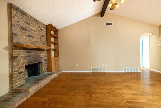 unfurnished living room with arched walkways, visible vents, and wood finished floors