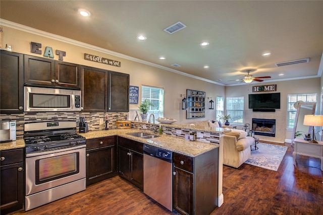 kitchen with visible vents, a sink, a peninsula, crown molding, and stainless steel appliances