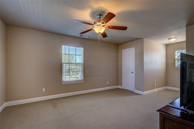 unfurnished living room featuring visible vents, baseboards, ceiling fan, and light carpet
