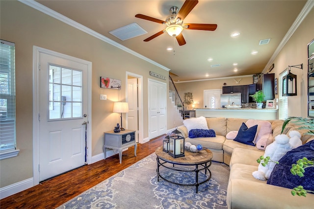 living room with visible vents, ornamental molding, ceiling fan, wood finished floors, and stairs