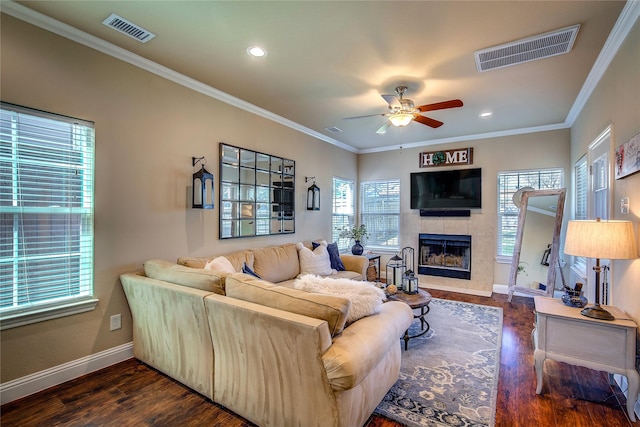 living area featuring a tiled fireplace, ceiling fan, baseboards, and visible vents
