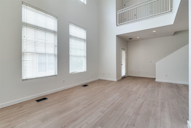 3251 Cambrick St Unit 13, Dallas, TX 75204 - unfurnished living room with light wood finished floors, baseboards, visible vents, and a wealth of natural light