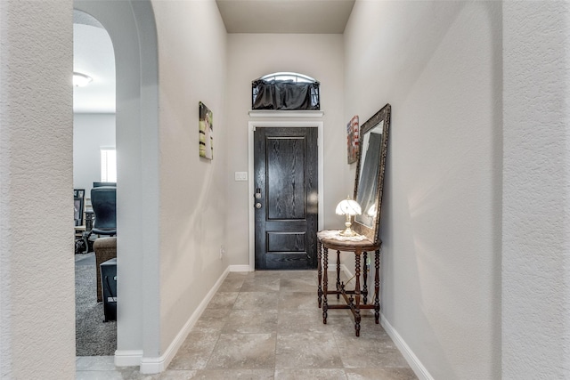 entrance foyer with arched walkways and baseboards