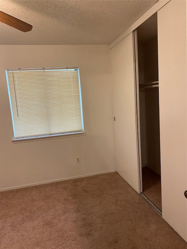5607 Harvest Hill Rd Unit 2008, Dallas, TX 75230 - unfurnished bedroom with ceiling fan, a closet, a textured ceiling, and carpet floors