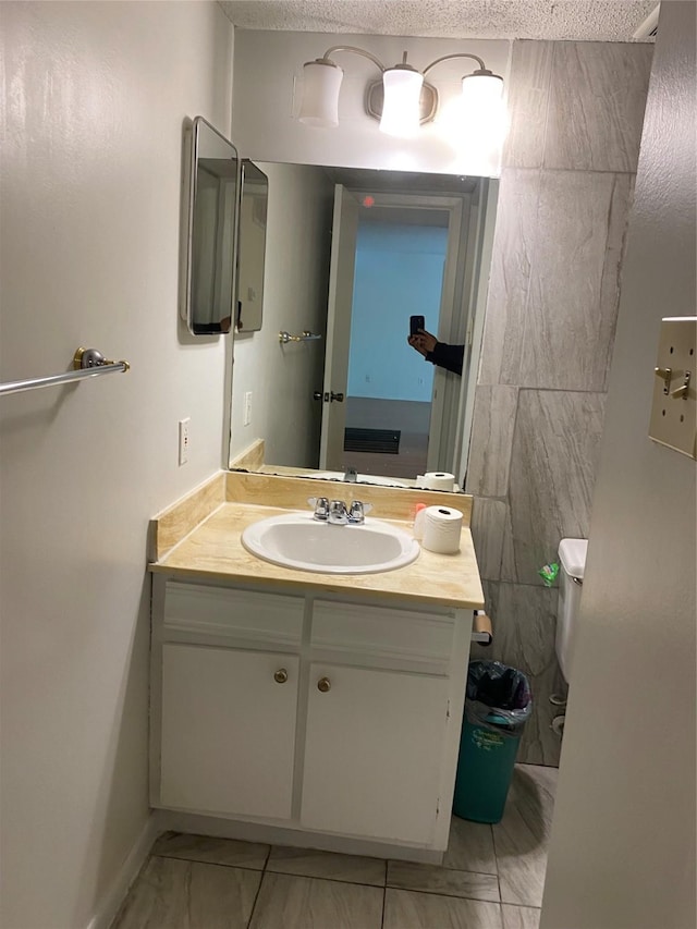 5607 Harvest Hill Rd Unit 2008, Dallas, TX 75230 - half bath featuring vanity, baseboards, a textured ceiling, toilet, and marble finish floor