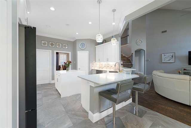 523 Buffalo Bend Ct, Murphy, TX 75094 - kitchen with arched walkways, crown molding, white cabinets, a peninsula, and light countertops