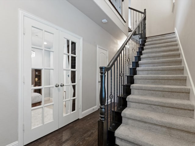 stairs with french doors, baseboards, and wood finished floors