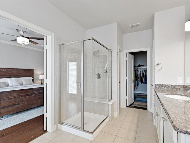 bathroom with ceiling fan, visible vents, a stall shower, vanity, and tile patterned floors