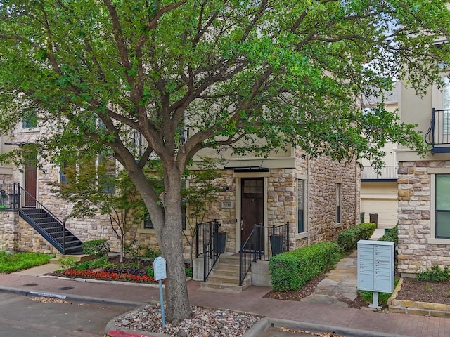 view of front of property featuring stairway and stone siding