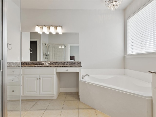 bathroom featuring tile patterned flooring, vanity, a garden tub, a shower stall, and a notable chandelier