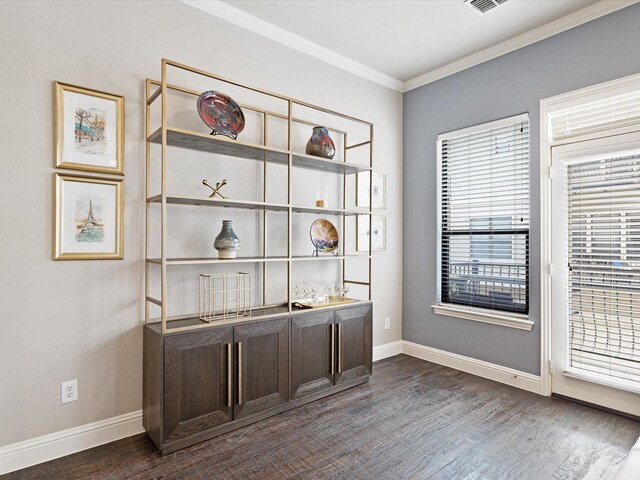 unfurnished office with crown molding, dark wood-style flooring, and baseboards