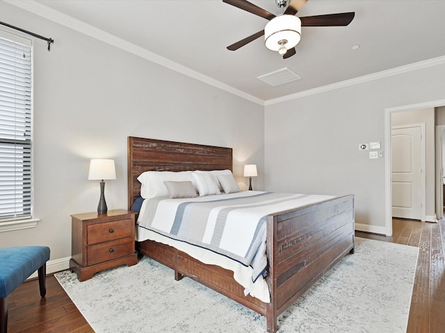 bedroom with visible vents, ornamental molding, wood finished floors, baseboards, and a ceiling fan