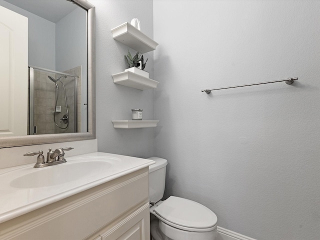 bathroom featuring vanity, a shower stall, and toilet
