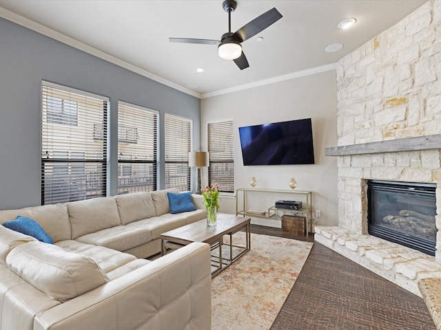 living room with ornamental molding, a fireplace, and a ceiling fan