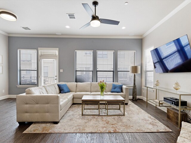 living area featuring visible vents, crown molding, plenty of natural light, and wood finished floors