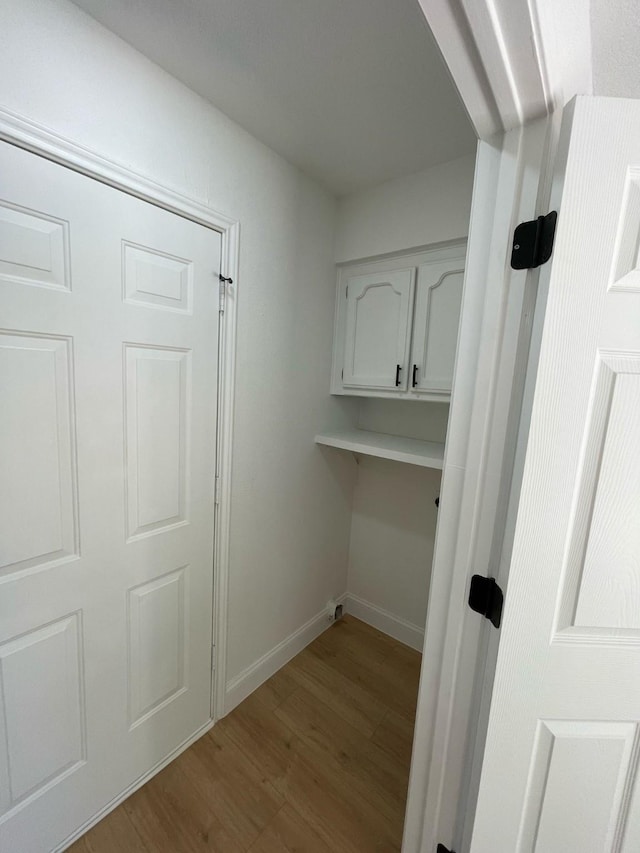 washroom with baseboards and wood finished floors