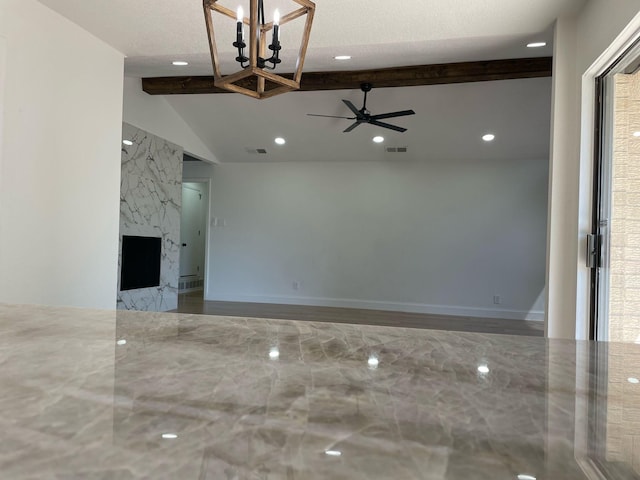 unfurnished living room with visible vents, vaulted ceiling with beams, recessed lighting, and ceiling fan with notable chandelier