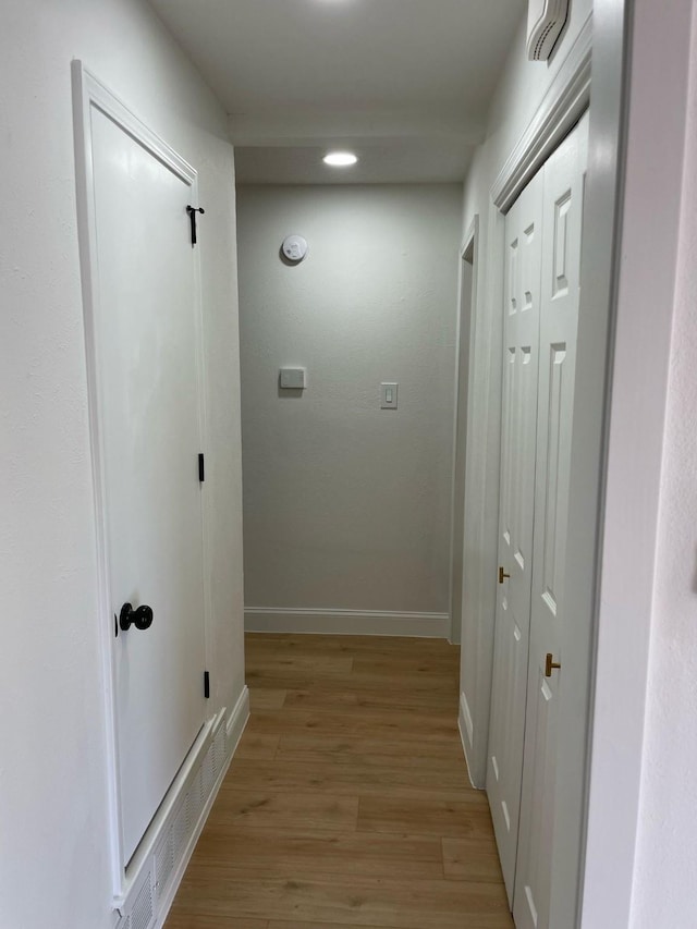 corridor with visible vents, baseboards, recessed lighting, and light wood-style floors
